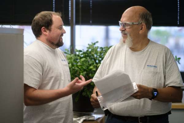 Two men smiling while talking
