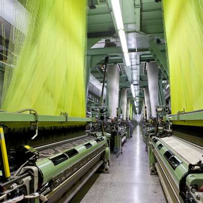 textile plant with yellow colorful thread hanging on both sides of shot